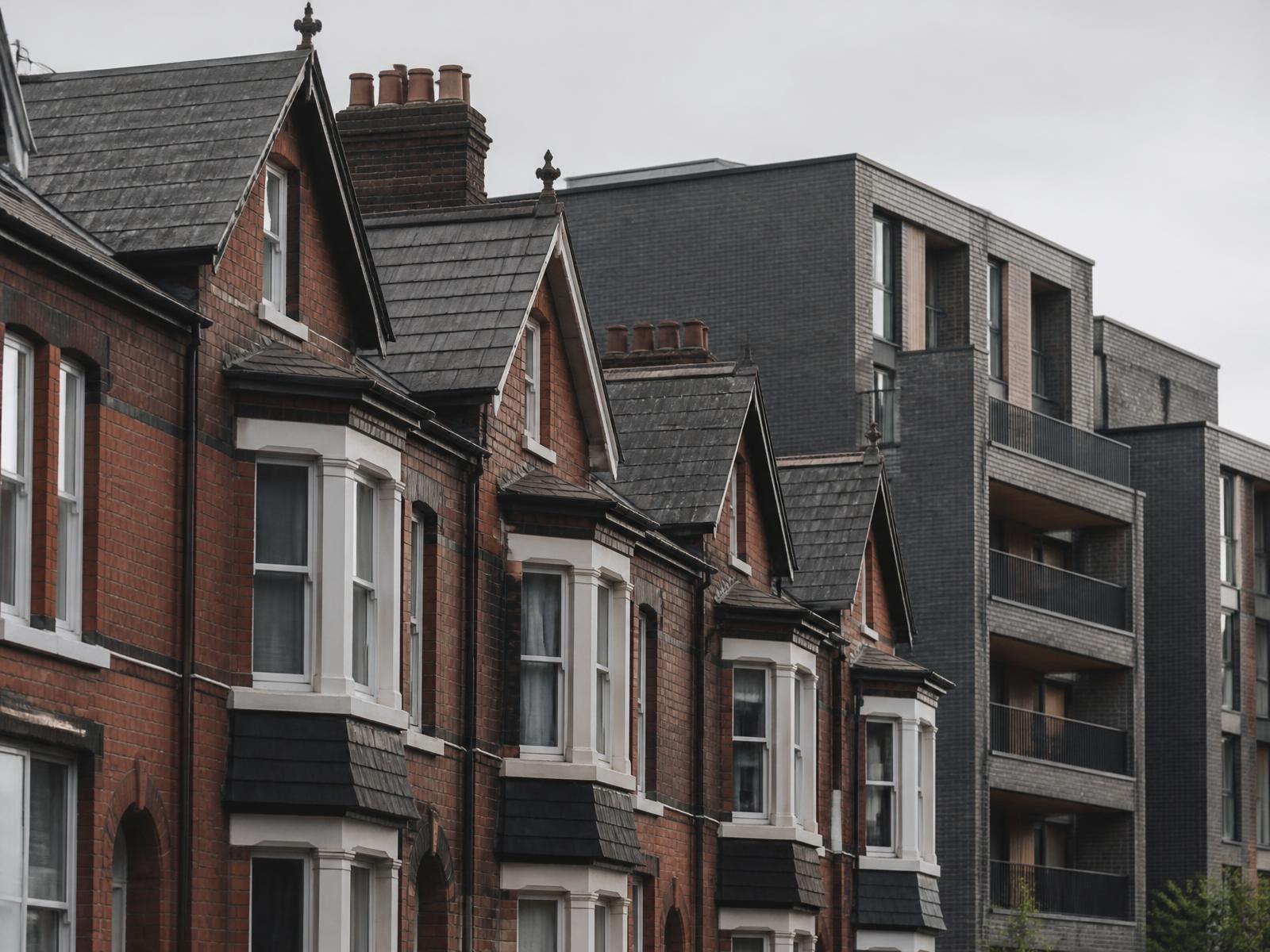 Victorian terraced housing beside a modern apartment building on a Greater Manchester street